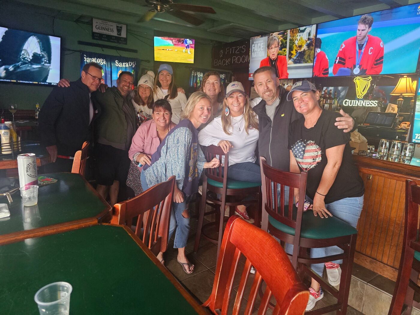 Friends enjoying drinks at the Fitzgerald's bar beneath Guinness signs
